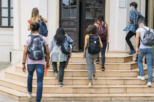 Group of students walking in college, they wearing protective face masks.